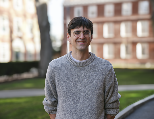 Andrew Bair wearing grey sweater in Harvard Yard