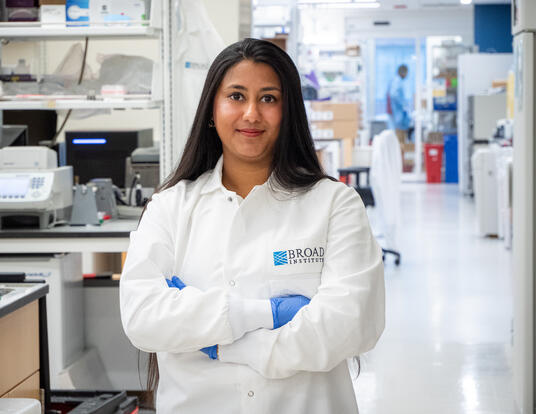 Arya in her white lab coat in the lab at the Broad Institute