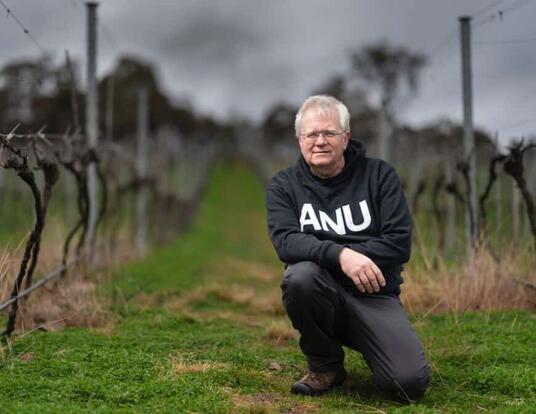 Brian Schmidt kneeling outdoors