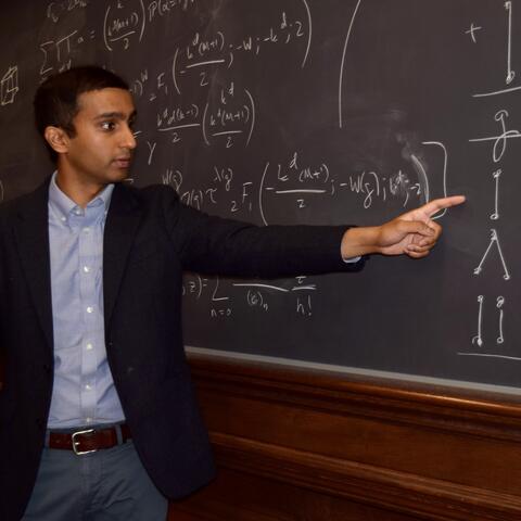 PhD student Vaibhav Mohanty lecturing at a blackboard on theoretical chemistry