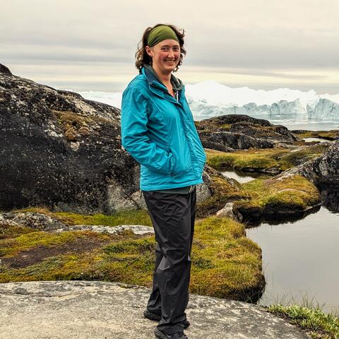 Kara Hartig standing in front of an iceberg