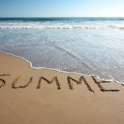 ocean tide washing away the word "Summer" written into the beach sand