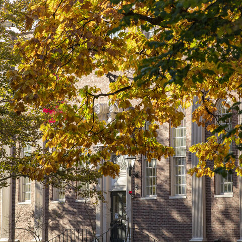 Lehman Hall, GSAS Student Center, through trees beginning to change colors