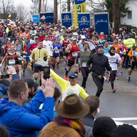 a wave of enthusiastic runners beginning the Boston Marathon
