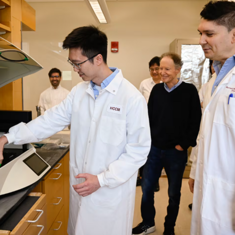 Dr. Bruce Yankner (center) watched as Zhen Kai Ngian (left) described the role of a digital droplet PCR machine used in the team's Alzheimer's research at the lab in the Harvard Medical research building.