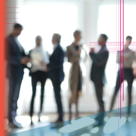 Blurred stock photo of six office workers speaking with each other. 