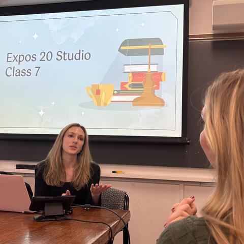 Presiozo sitting in front of screen and teaching students