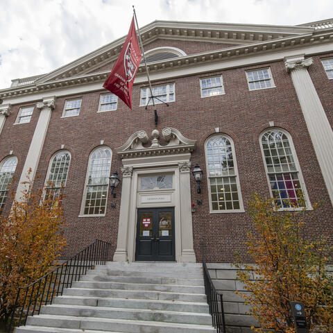 exterior of Lehman Hall with updated GSAS flag and fall leaves