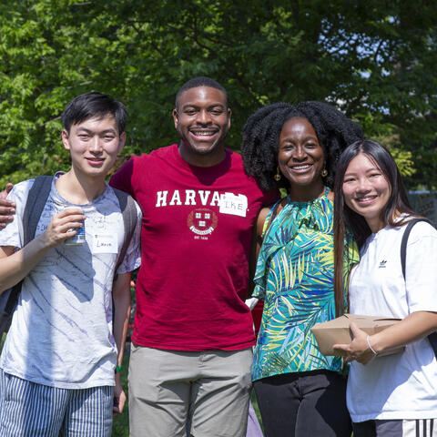 Four students smile together