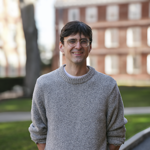 Andrew Bair wearing grey sweater in Harvard Yard