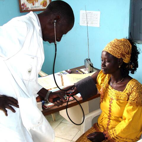 Senegalese medical professional checking a patient's blood pressure.