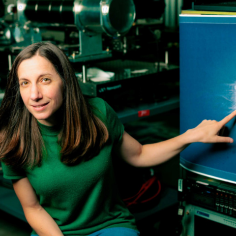 Astrophysicist Jenna Samra pointing at an image of the sun