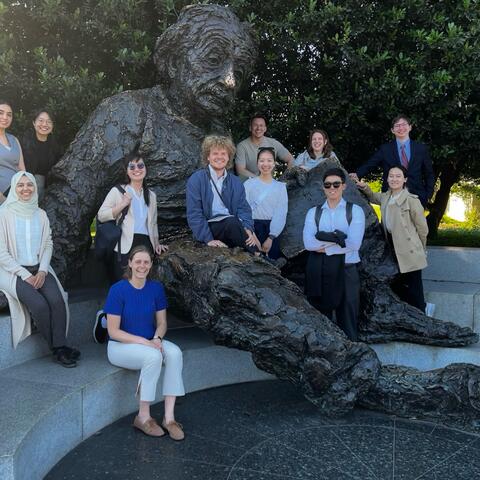 group of students sit along the large Albert Einstein statue in Washington, D.C.