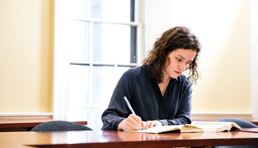 Lusia Zaitseva writing at a desk