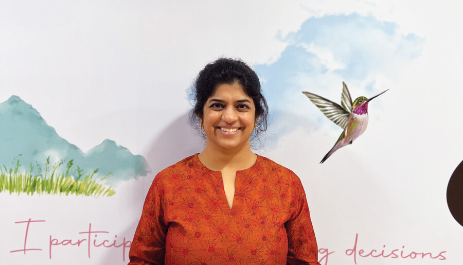 Nilekani poses in front of artwork in Aastrika Midwifery Centre