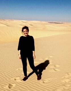 Chloe Bordewich standing in front of a sand dune