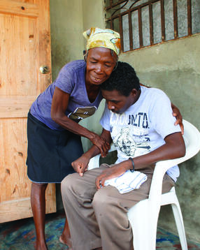Berkowitz's patient Janel (seated) with his mother outside of their home in Haiti in 2018