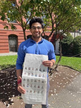 PhD student Aayush Karan holding a copy of the New York Times that lists the 2024 Soros New Americans