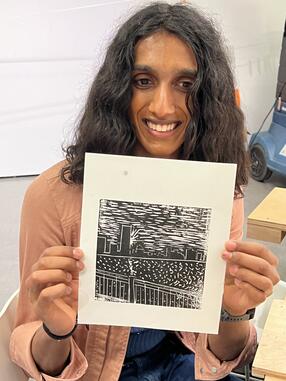 A student holds up a print they made during a Black History month wood block workshop