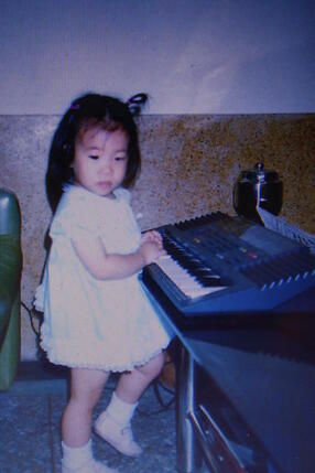 Michele Cheng as a young toddler playing piano.