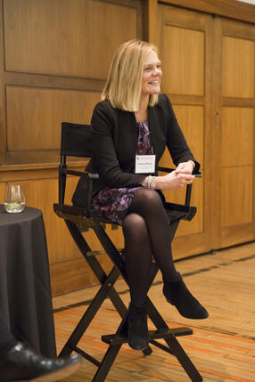 Emma Dench sitting in chair smiling at an event