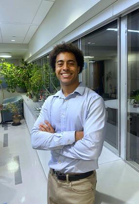headshot of Isaias in blue collared shirt and hands crossed