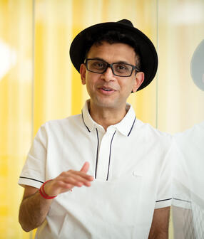 Rohan Murty wearing black hat and white shirt