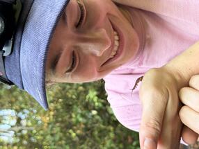 Close-up of Arianna Lord smiling and holding velvet worm 