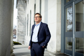 Jason Furman in front of tall building structures 