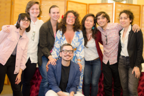 A group of student surrounds Sergio Delgado Moya, posing for a photo