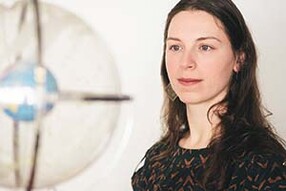 Elizabeth Newton, Harvard Horizons scholar, in front of world globe inside clear glass orb with metal bands