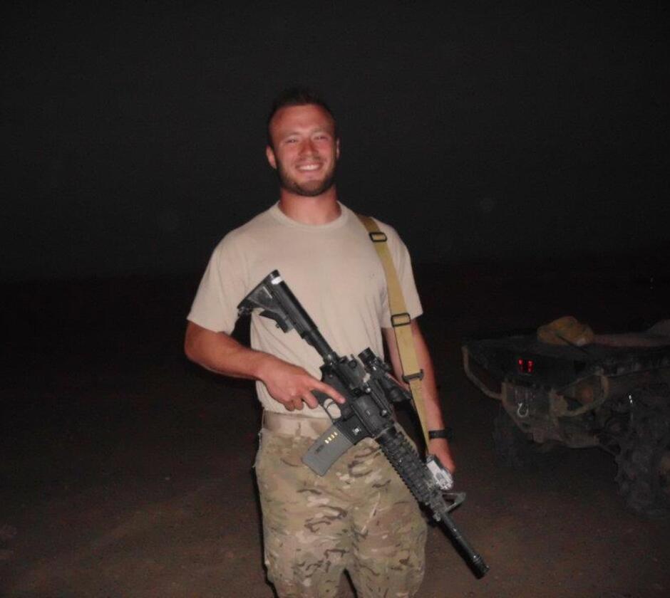 Bellet holding automatic weapon after patrol in Afghanistan